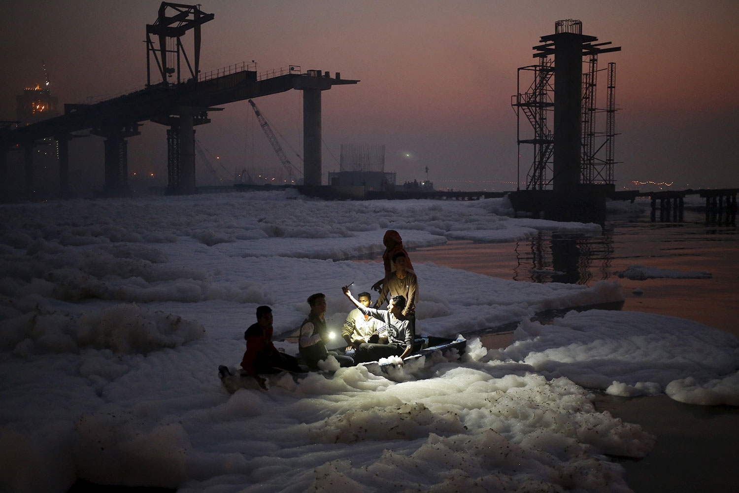 A Hindu devotee takes his selfie while sitting on a boat in the polluted waters of Yamuna river during the Hindu religious festival of Chatt Puja in New Delhi