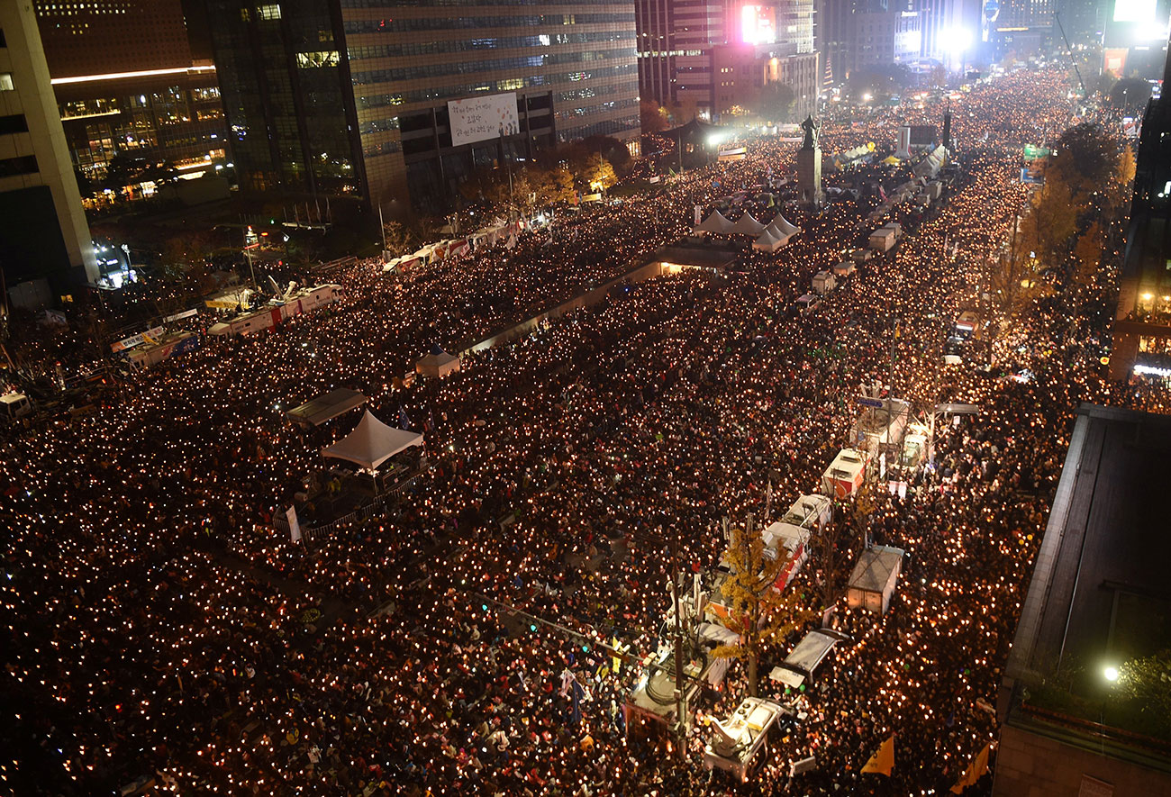 Protesters hold candles during an anti-government rally in central Seoul