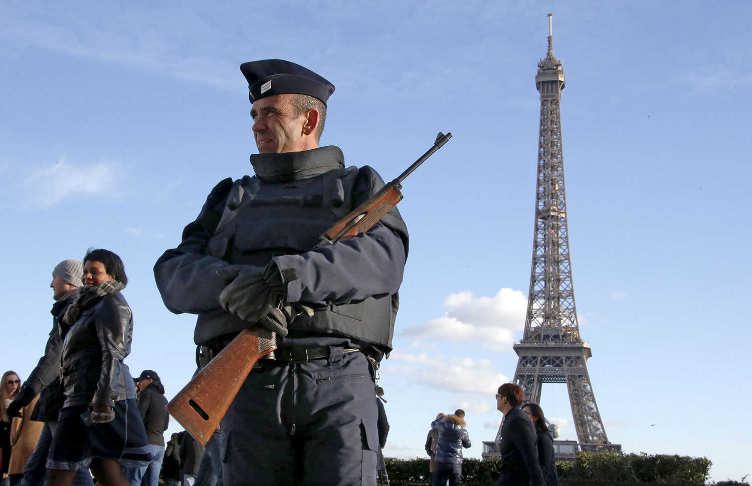 A French police officer stands guard by the Eiffel tower a week after a series of deadly attacks in the French capital Paris
