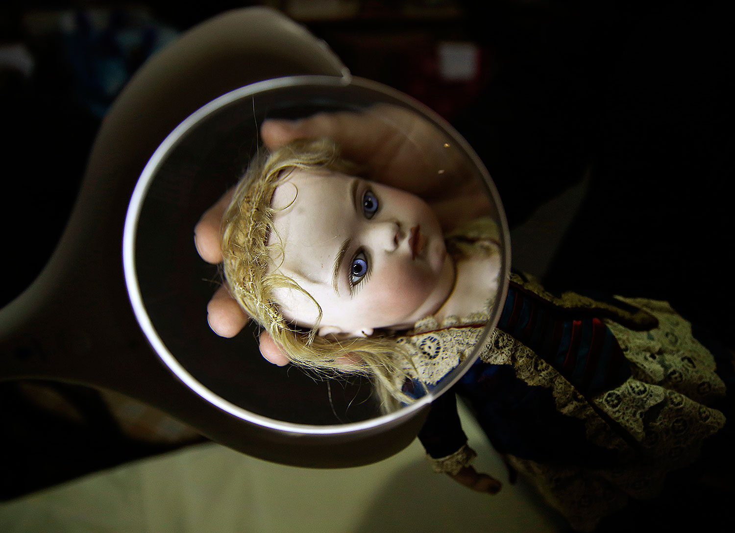 A worker examines a French bisque doll at the Vectis auction house in Stockton-on-Tees