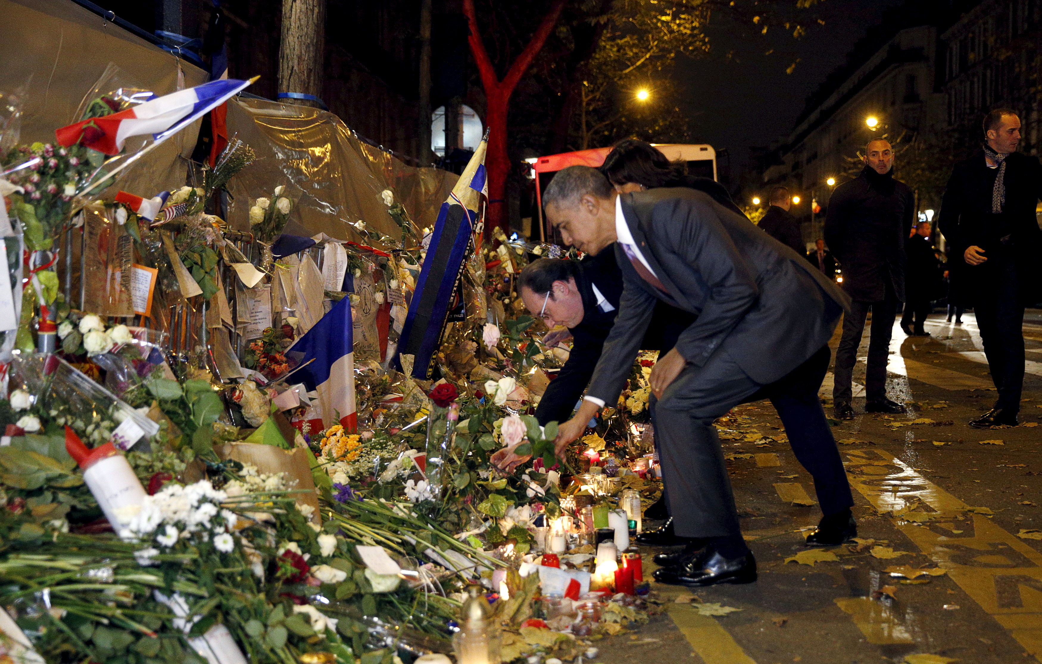 French President Francois Hollande and U.S. President Barack Obama place flowers at a  makeshift memorial to pay tribute to the victims of the Paris attacks at the Bataclan in Paris