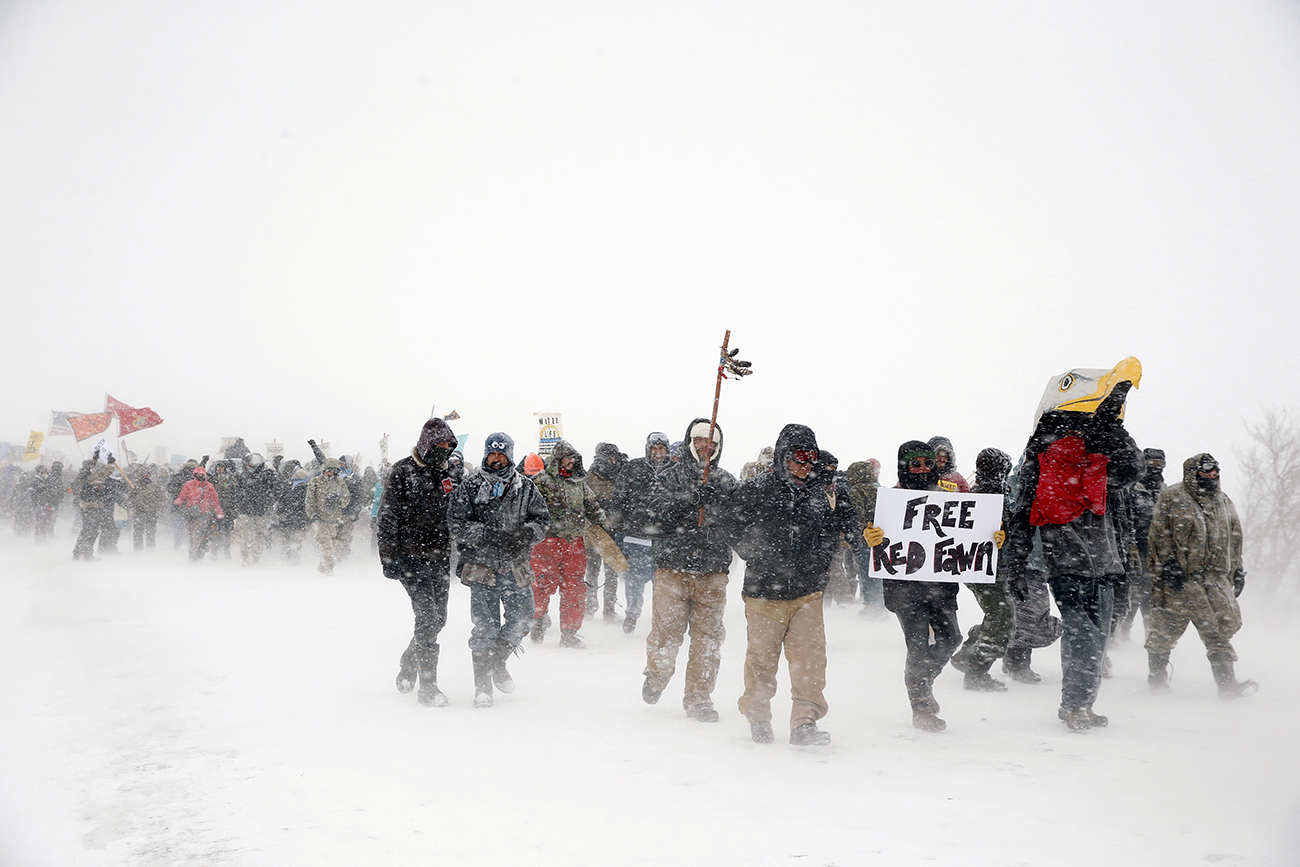 Veterans join activists in a march just outside the Oceti Sakowin camp during a snow fall as "water protectors" continue to demonstrate against plans to pass the Dakota Access pipeline adjacent to the Standing Rock Indian Reservation, near Cannon Ball,