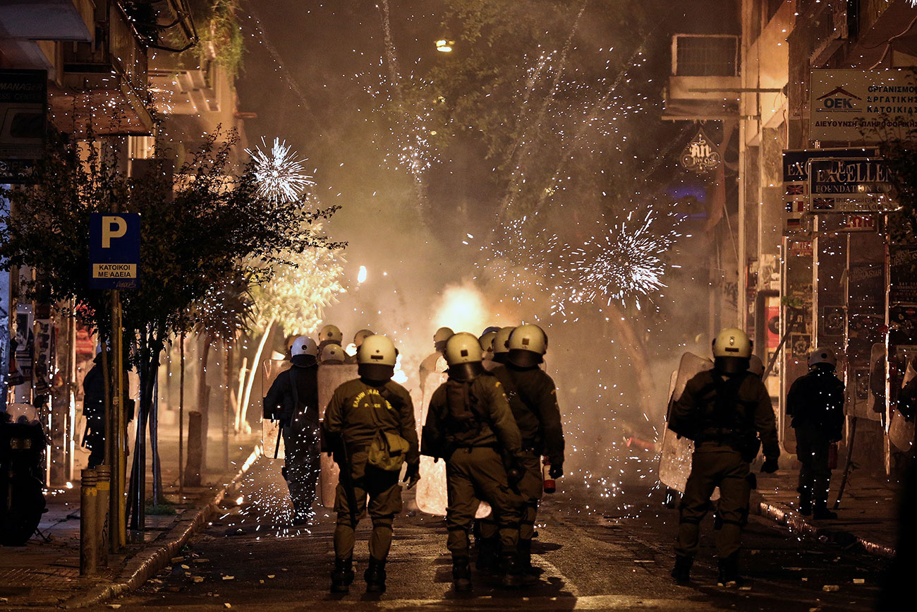 Fireworks explode next to riot police during clashes following an anniversary rally marking the 2008 police shooting of 15-year-old student, Alexandros Grigoropoulos, in Athens