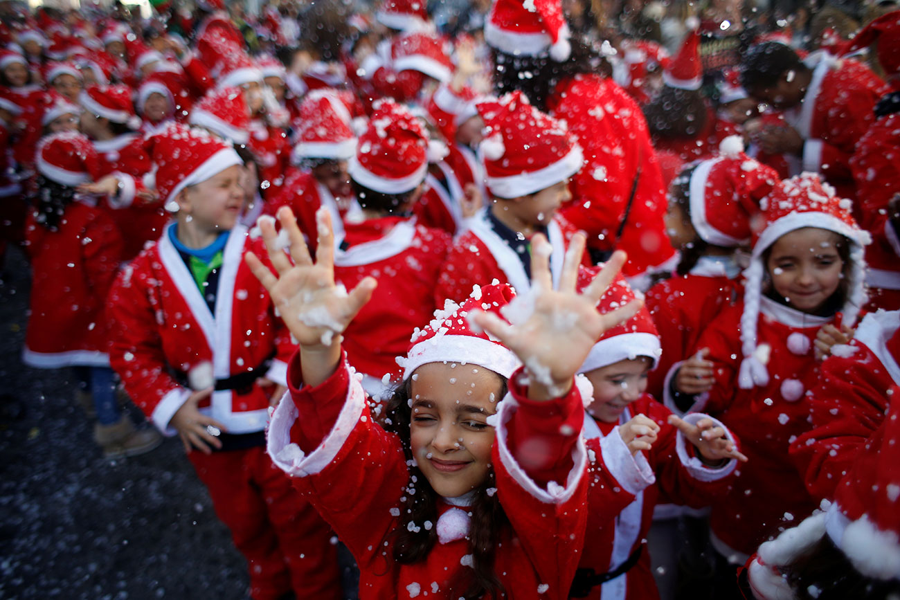 Children dressed as Santa Claus participe in a parade held to collect food for the needy, in Lisbon