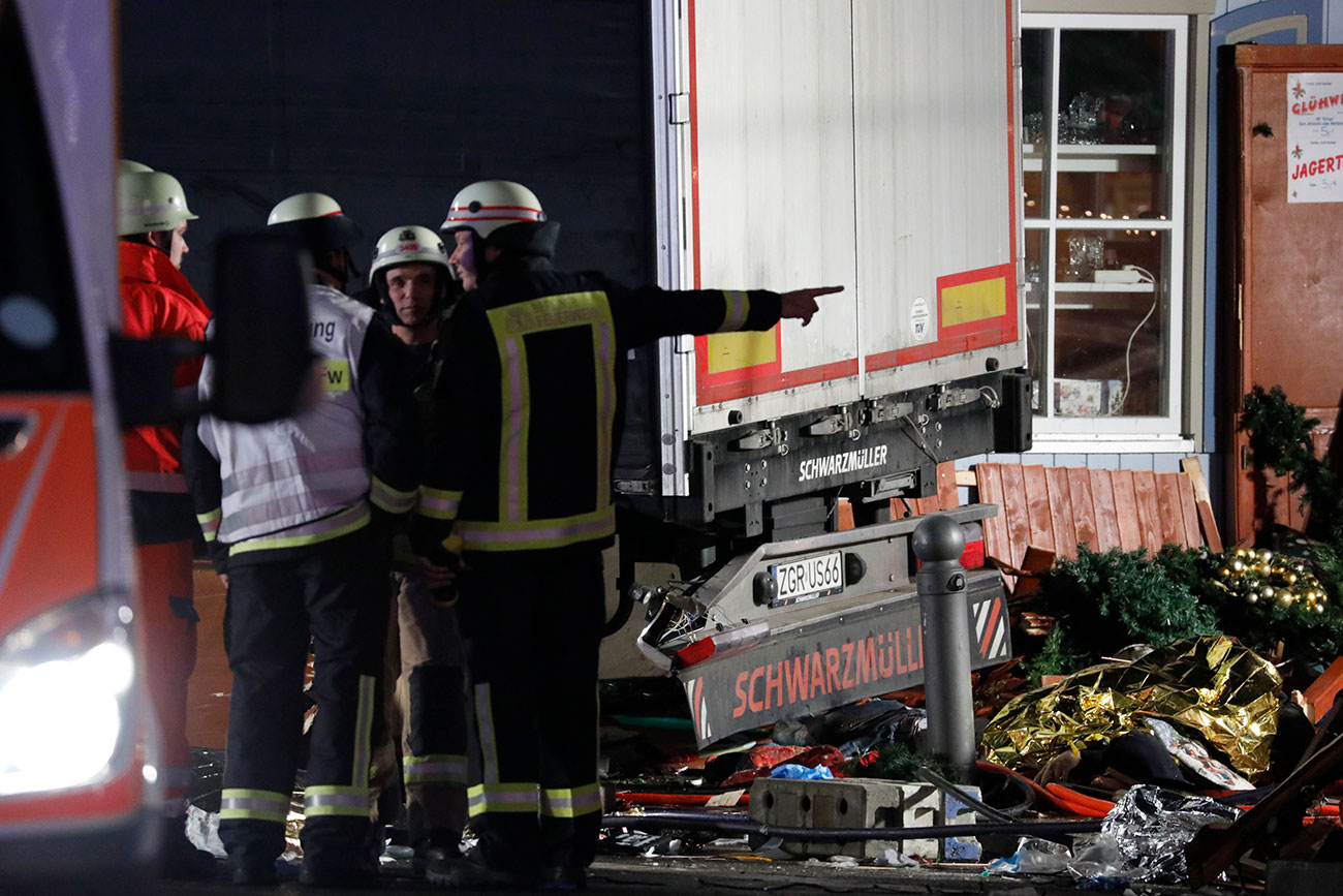 Firefighter stand beside a truck at a Christmas market in Berlin