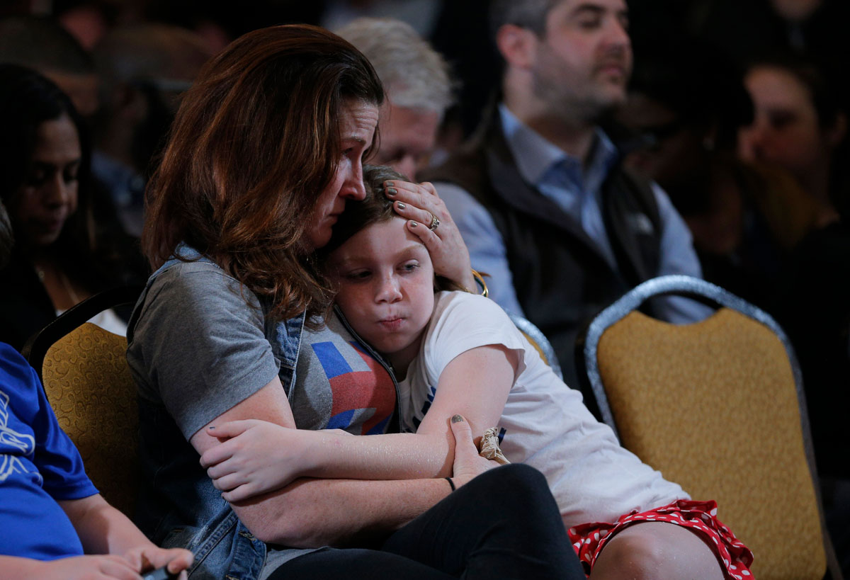 A member of the campaign staff of former Democratic U.S. presidential candidate Clinton hugs her young daughter as they wait for Clinton to appear and speak after losing the election at a hotel in the New York