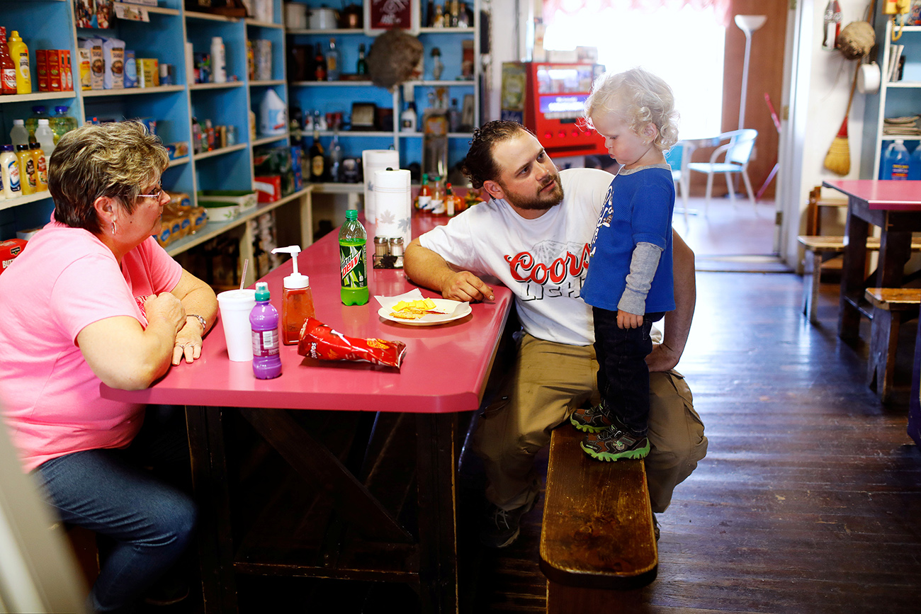 Employee Joyce Chandler looks on as Antonin Bohac encourages his son, Sawyer, to eat in Bixby