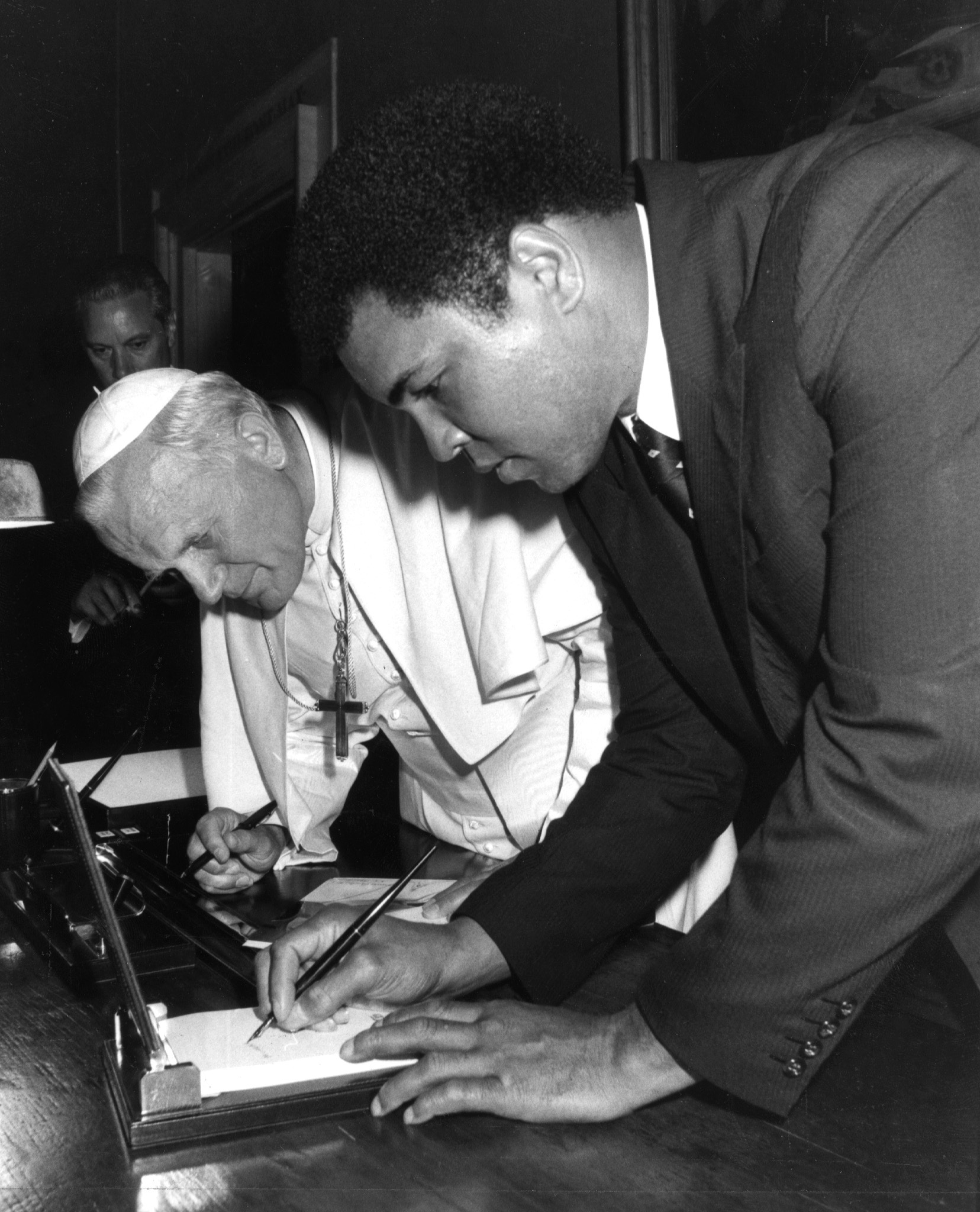 POPE AND BOXER MUHAMMAD ALI EXCHANGE AUTOGRAPHS AT THE VATICAN.