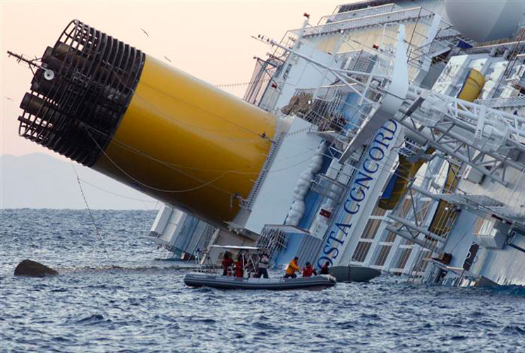 Rescuers stand in a boat next to the Costa Concordia cruise ship that ran aground off the west coast of Italy, at Giglio island on January 15.