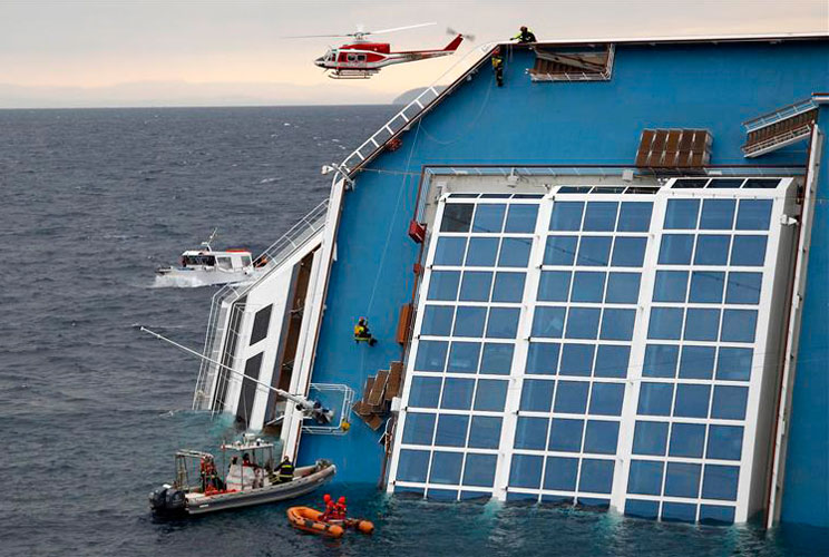 Rescue workers climbs up the capsized cruise ship.