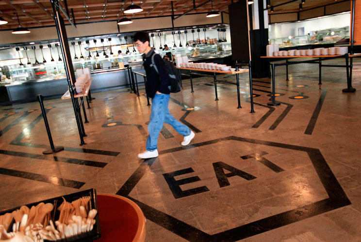 An employee walks through the cafeteria. 