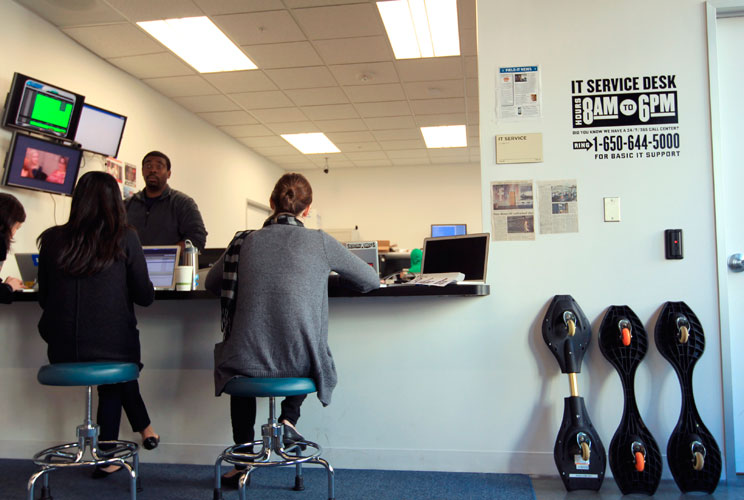 Employees wait at the IT service desk.  