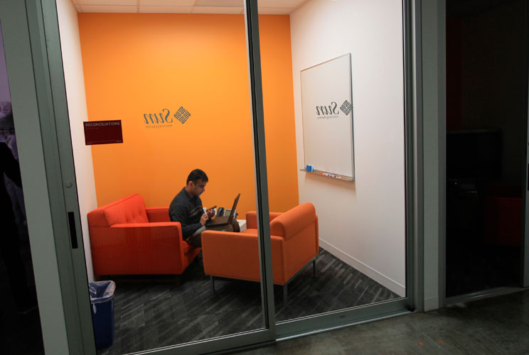 An employee works in one of many "cozies," tiny, personal conference rooms. 