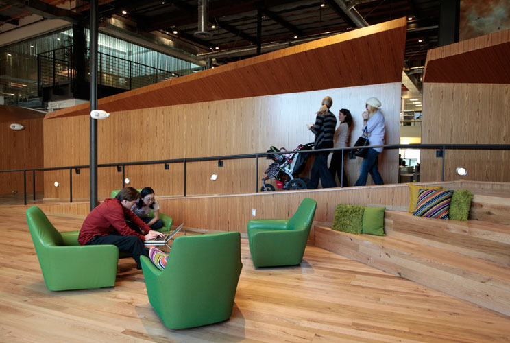 Employees sit in the "Boardwalk" workspace. 