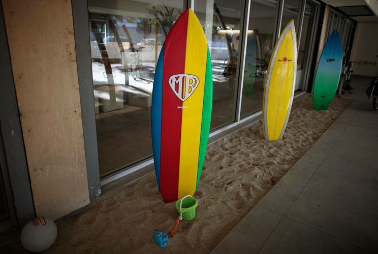 Surfboards for use by employees are lined up. 