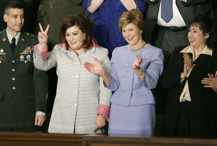 First lady Laura Bush applauds with her special guest Homira Nassery (at right), while guest Safia Taleb al-Souhail, leader of the Iraqi Women's political council, gives a victory sign next to Army Staff Sergeant Norbert Lara.