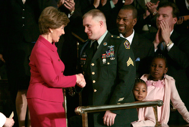 U.S. first lady Laura Bush greets U.S. Army Sgt. Tommy Rieman as she arrives for the State of the Union speech on January 23, 2007. President Bush related Rieman's story "In December 2003, he was on a reconnaissance mission in Iraq when his team came unde