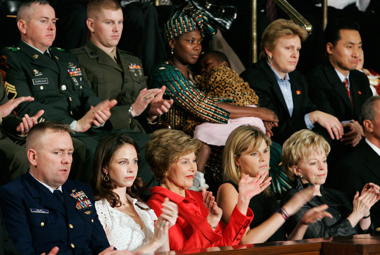 In President Bush's final State of the Union address, U.S. Coast Guard Petty Officer Wil Milam (bottom left), U.S. Army Staff Sergeant Craig Charloux (top left), U.S. Marine Corps Lieutenant Andrew Kinard (top 2nd left), and Tatu Msangi and her daughter F