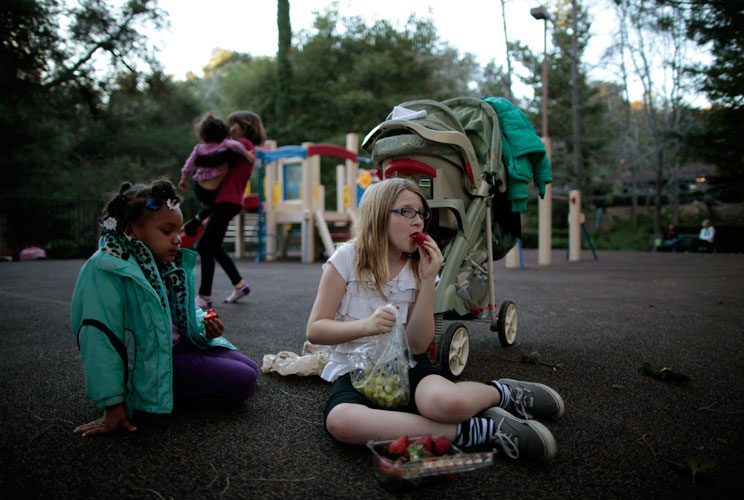 Lindzy Earp (R), 10, sits in the playground with Deja Mass, 5.  