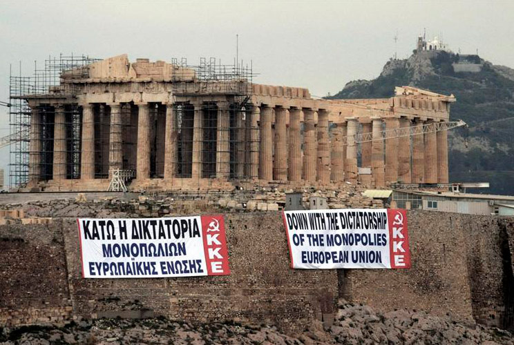 Two anti-austerity banners, placed by activists of the Greek Communist party, are displayed on a hill at the Acropolis in Athens February 11, 2012. Greek lawmakers will vote this weekend on a controversial austerity bill that Athens needs to avoid a messy