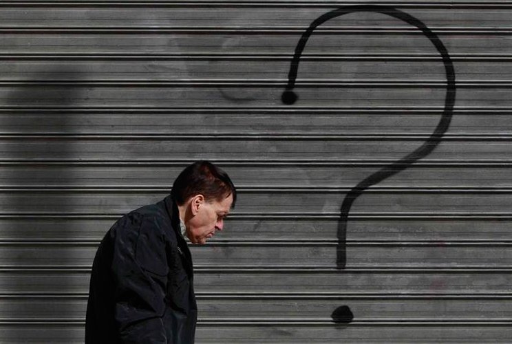 A man walks in front of a closed bank branch in central Athens February 11 2012.