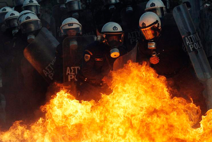 A petrol bomb explodes near riot police during an anti-austerity demonstration in Athens' Syntagma (Constitution) Square February 12, 2012.