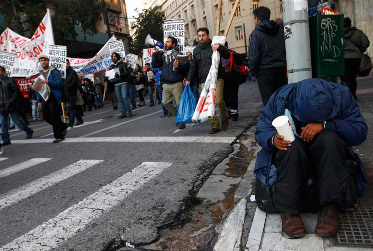 A man begs on a street in athens during a demonstration in Athens February 12, 2012.