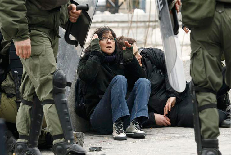 Demonstrators are detained by riot police during protests against planned reforms by Greece's coalition government in Athens, February 10, 2012. 