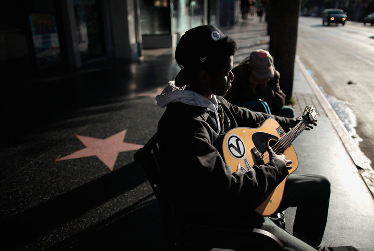 Josh Douglas, 19, (L) and Dawn Taylor, 22, sit on a bench on Hollywood Boulevard as the sun rises near the site of the 84th Academy Awards in Hollywood, California. When host Billy Crystal's joked during the Oscar's ceremony, "Nothing can take the sting o