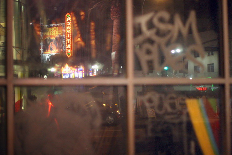 The El Capitan Theatre, across the street from the site of the 84th Academy Awards, is reflected in graffiti-covered windows.