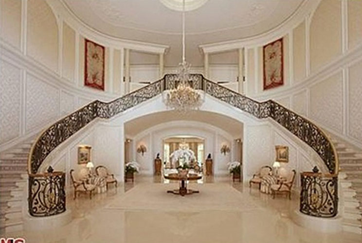 The three-story, seven-bedroom property sits on 4.7 acres, and includes a dog grooming room, five bars, a room solely for the purpose of displaying expensive China, a “gift-wrapping” room, a bowling alley, a beauty salon, and a grand double staircase insp