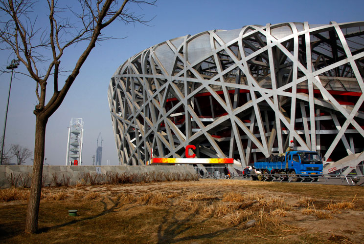 Workers unload a truck outside the National Stadium, also known as the "Bird's Nest", which was the venue for the athletics and the opening and closing ceremonies of the 2008 Olympic Games in Beijing March 23, 2012. The gigantic infrastructures built for 