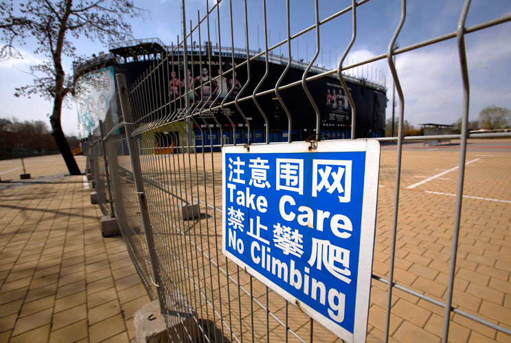 A security fence surrounds the deserted and unmaintained 2008 Beijing Olympics venue for the beach volleyball competition in central Beijing April 2, 2012. The gigantic infrastructures built for the Beijing Olympics, namely the National Stadium, better kn