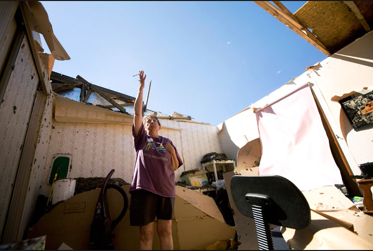 Cheryl Cyr shows a section where the roof of her home was ripped off. Cyr and her husband Carl were in the home during the tornado but neither were injured.