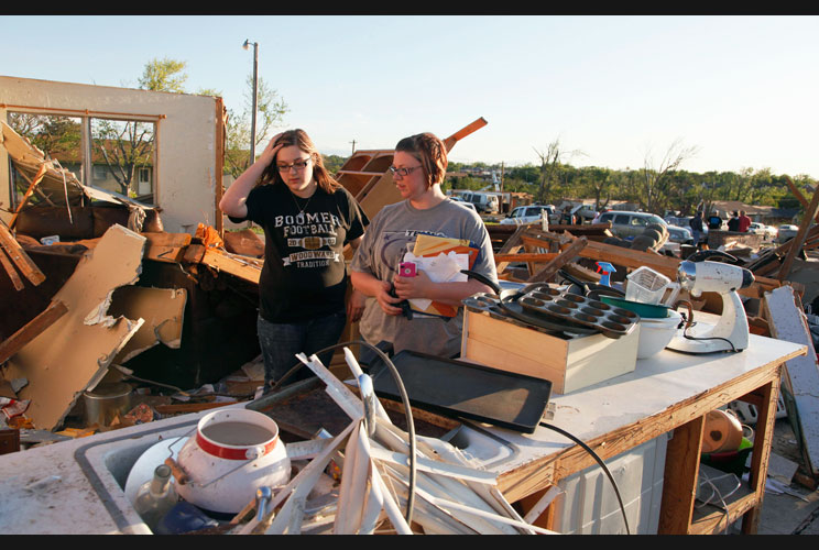 Aaryn Mashonhall (left) and Shanna Byrd sort through the debris in Masonhall's father's home that was destroyed by a tornado.