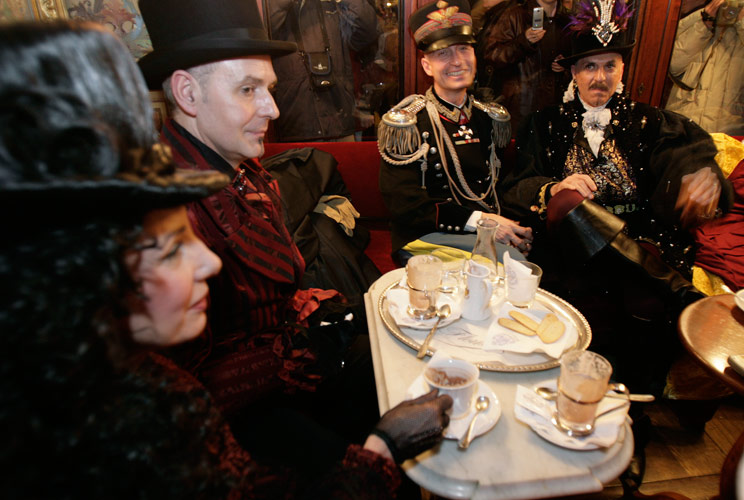 The very first coffee house in Europe is said to have opened in Venice in 1683, though coffee was available in Europe as early as 1608, mostly for the well-to-do. In this image, a group of costumed tourists enjoy a hot drink in Cafe Floriana in Saint Mark