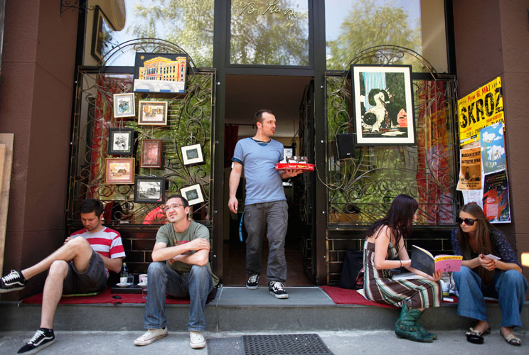 Almin Dzafic, a 30 year-old waiter, poses for a picture as he serves customers in the Galerija Boris Smoje cafe in Sarajevo, May 11, 2012. Dzafic studied for four years at Sarajevo University where he received a degree in civil engineering. For the last f