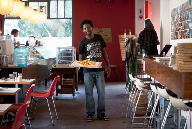 Terence Kamanda, a 25 year-old waiter, poses for a picture as he serves customers in The Corner Cafe restaurant in Durban, April 26, 2012. The Zimbabwean national studied for 18 months at the London Chamber of Commerce Institute College in Gweru, Zimbabwe