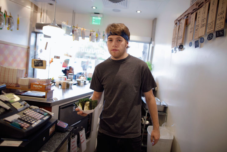 Steffen Andrews, a 24 year-old waiter, serves a customer at Sunny Blue restaurant in Santa Monica, California April 24, 2012. Andrews studied for four and a half years at Cabrillo College where he received a degree in communications. He came to Los Angele