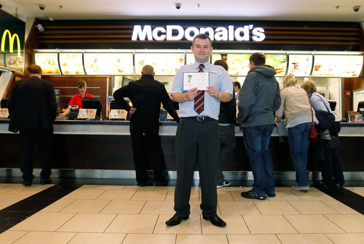 Marcin Lubowicki, a 28 year-old deputy manager of a McDonald's restaurant, poses with his university diploma in front of the fast food chain in the Arkadia shopping mall, Warsaw May 16, 2012. Lubowicki, who has degree in Russian language from Warsaw Unive