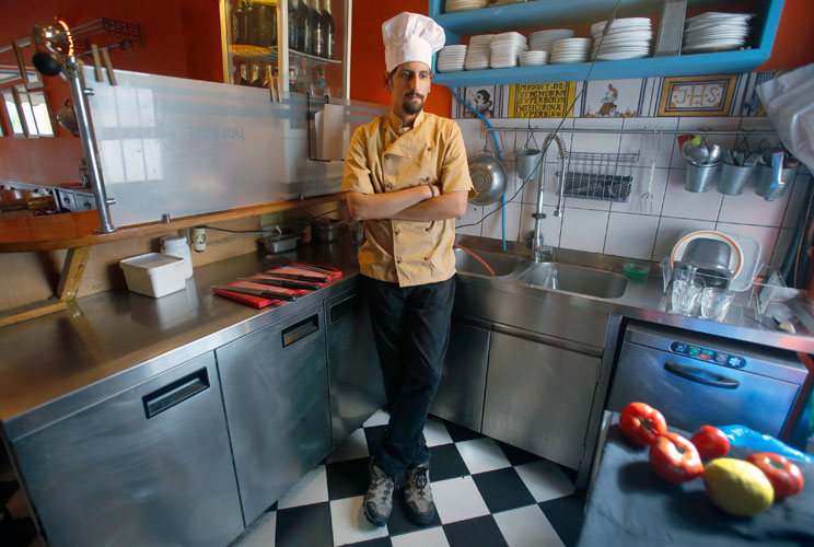 Manolis Ouranos, a 30 year-old cook, poses for a picture in the Mavros Gatos (Black Cat) tavern in Psiri neighboorhood in central Athens May 23, 2012. Manolis studied at Athens Technology University (TEI) for four years where he received a degree in civil