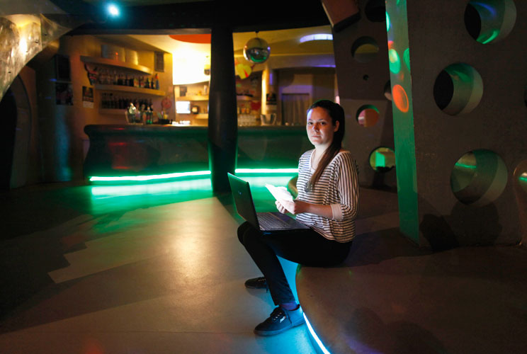 Daria Vitasovic, a 27 year-old bar manager, poses for a picture as she works on her laptop in a night bar in Zagreb, May 8, 2012. Vitasovic studied for seven years at Society of Jesus University where she received a degree in philosophy and religious scie