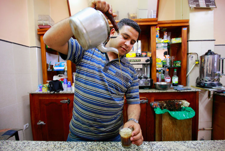 Sofiane Moussaoui, a 26 year-old waiter, poses for a picture as he serves tea for customers in a cafe in Algiers, April 22, 2012. Moussaoui studied for five years at the University 08 May 1945 Guelma where he received a masters degree in corporate finance