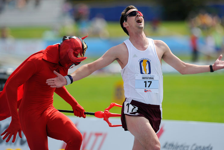 David Therrien gets stabbed by the Devil in the men's 5000 metre devil's run at the Donovan Bailey Invitational track and field meet in Edmonton, Alberta June 16, 2012. During the devil's run, the man in the last place on each lap can be caught by the dev