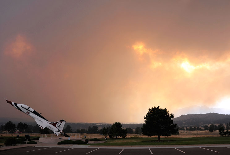 A T-38 Thunderbird on static display is surrounded by a rapidly spreading smoke cloud from the Waldo Canyon fire, not far from the Air Force Academy's airfield in Colorado Springs, June 26, 2012. Firefighters struggled on Wed. to beat back an aggressive w