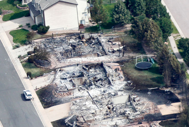 A child's trampoline, at right, sits intact in the backyard of one of hundreds of destroyed homes in the aftermath of the Waldo Canyon fire in Colorado Springs, June 28, 2012. Cooler temperatures and lighter winds helped firefighters Thursday in the battl