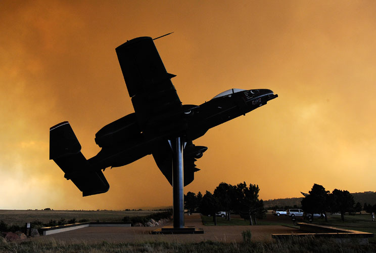 An A-10 aircraft on static display is silhouetted against a smoke cloud from the Waldo Canyon fire at the Academy's airfield in Colorado Springs, Colorado, in a photo dated June 26, 2012. The wildfire that forced the evacuation of 35,000 people from the e