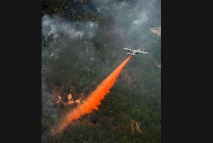 A U.S. Air Force C-130 Hercules aircraft spreads fire retardant to fight the Waldo Canyon wildfire in Colorado Springs, Colorado, in this  June 28, 2012 handout photo. The Waldo Canyon fire, which started June 23, 2012, burned several hundred homes and fo