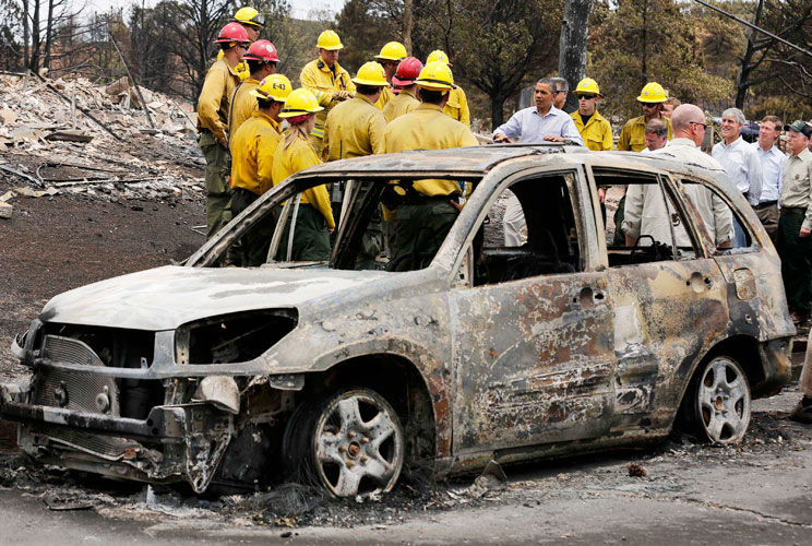 U.S. President Barack Obama surveys fire damaged homes in the Mountain Shadow neighborhood while next to first responders in Colorado Springs, Colorado, June 29, 2012. Obama declared the areas a federal disaster area, thereby releasing federal funds to he