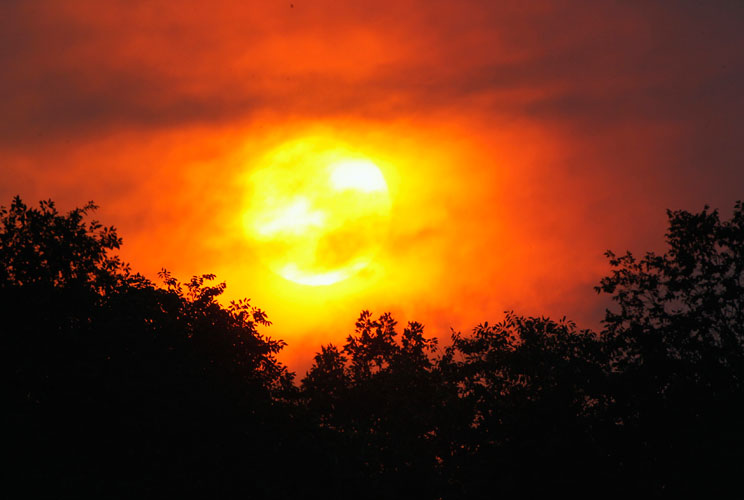 The sun illuminates through the smoke from the Waldo Canyon fire, west of Colorado Springs, June 24. The fast-growing wildfire that blew up overnight in Colorado has forced 11,000 people from their homes and was threatening popular summer camping grounds 